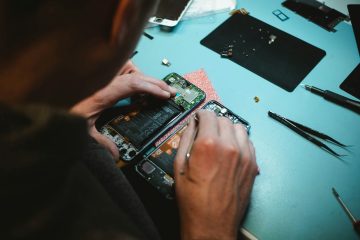 person repairing smartphones under a lighted table